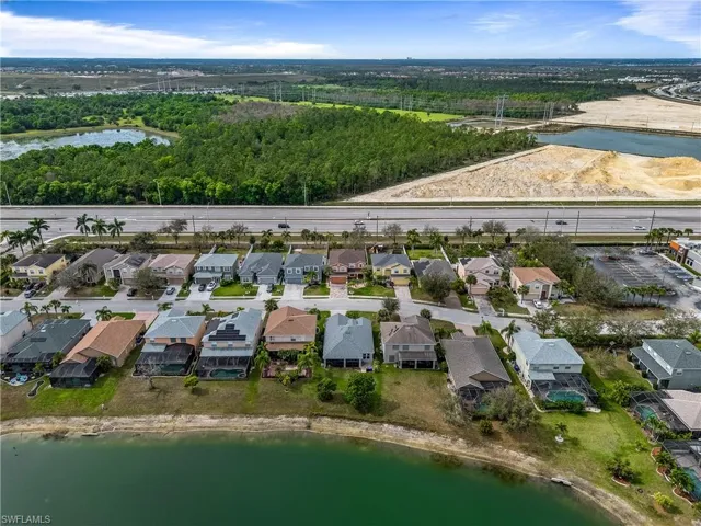 Birds eye view of property with a water view and a residential view