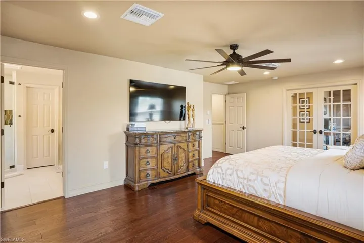 Bedroom with recessed lighting, visible vents, wood finished floors, and french doors