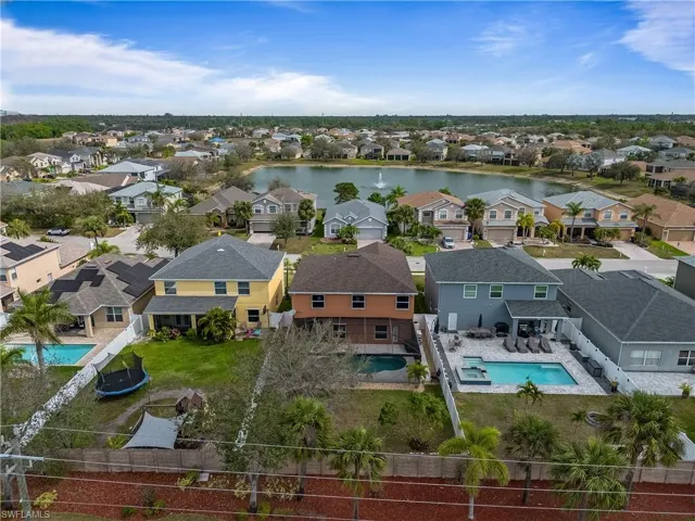 Birds eye view of property with a water view and a residential view