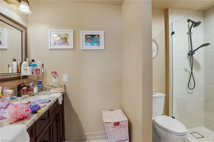 Full bath featuring vanity, toilet, and a shower stall
