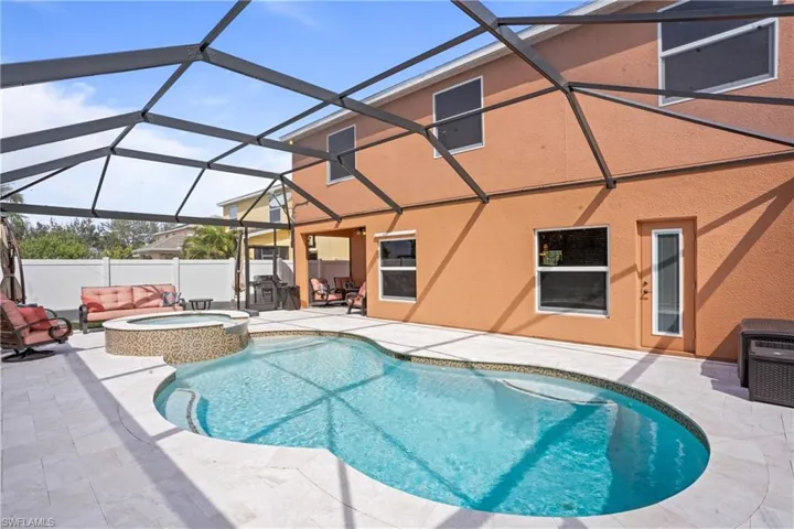 View of pool with a fenced in pool, a patio area, glass enclosure, fence, and an in ground hot tub