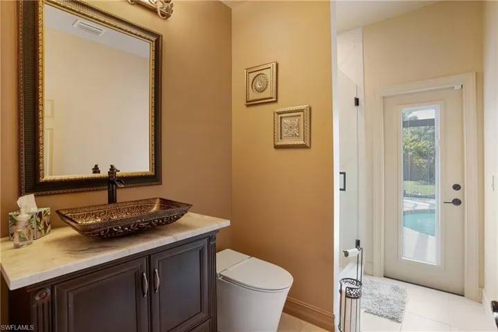 Bathroom featuring toilet, tile patterned floors, visible vents, and vanity