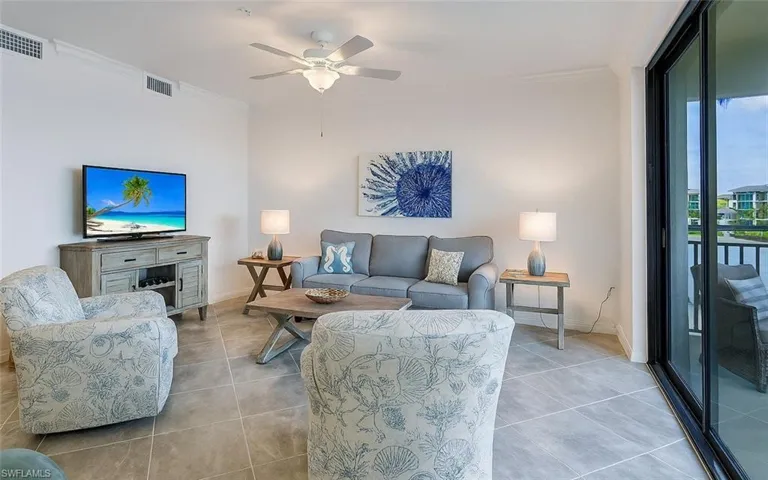 Tiled living area featuring ornamental molding and ceiling fan