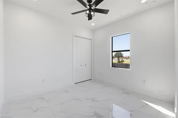 Unfurnished bedroom with light marble finish flooring, ceiling fan, a closet, and recessed lighting