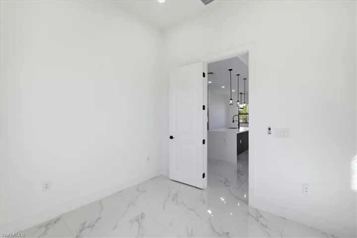 Unfurnished room featuring light marble finish floors and recessed lighting