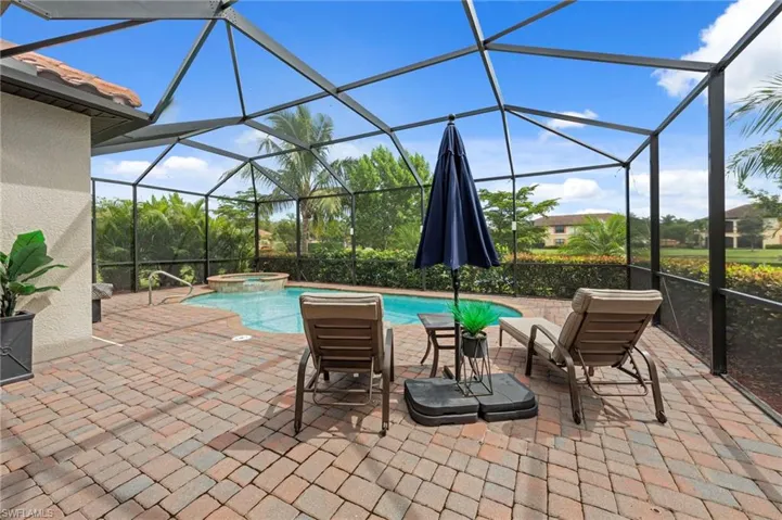 View of swimming pool with a sunroom, a patio, a pool with connected hot tub, and glass enclosure