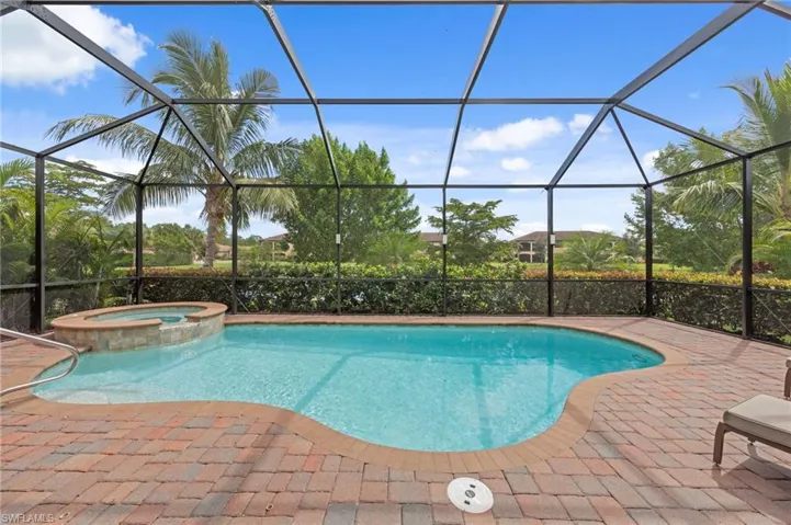 View of swimming pool featuring a sunroom, a pool with connected hot tub, and a lanai
