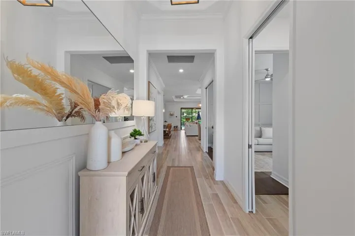 Hallway featuring ornamental molding and light wood-style flooring