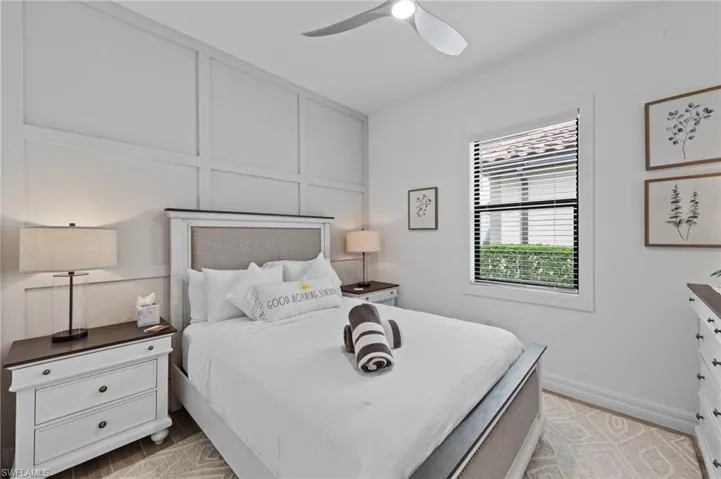 Bedroom featuring a decorative wall, a ceiling fan, and light wood-style flooring