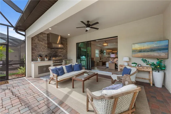 View of patio with exterior kitchen, a sunroom, a lanai, a ceiling fan, and an outdoor hangout area