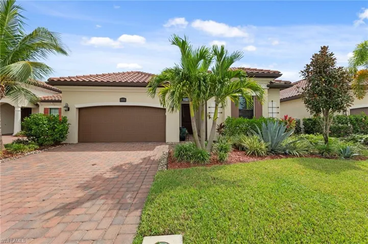 Mediterranean / spanish-style house featuring decorative driveway, stucco siding, a front yard, and a garage
