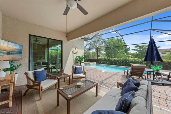 View of patio / terrace featuring a ceiling fan, an outdoor hangout area, a sunroom, glass enclosure, and a pool with connected hot tub