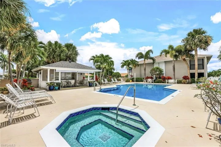 View of pool featuring a hot tub and a patio area