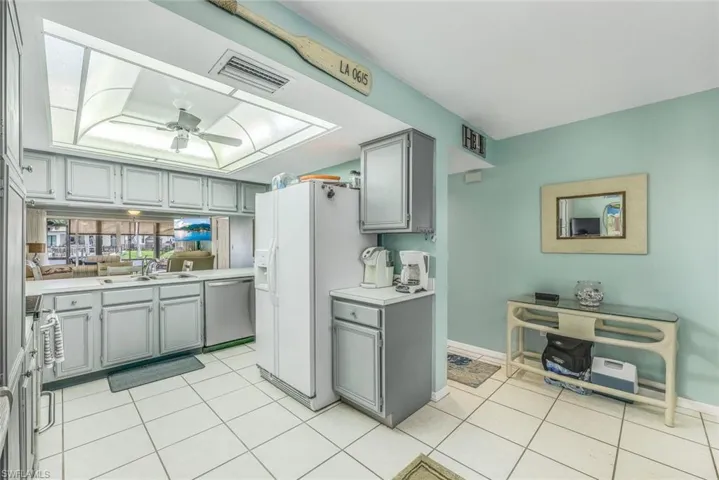 Kitchen featuring ceiling fan, gray cabinets, sink, dishwasher, and light tile floors