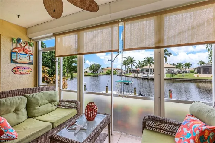 Sunroom / solarium featuring ceiling fan and a water view