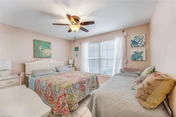 Bedroom with ceiling fan and light tile floors