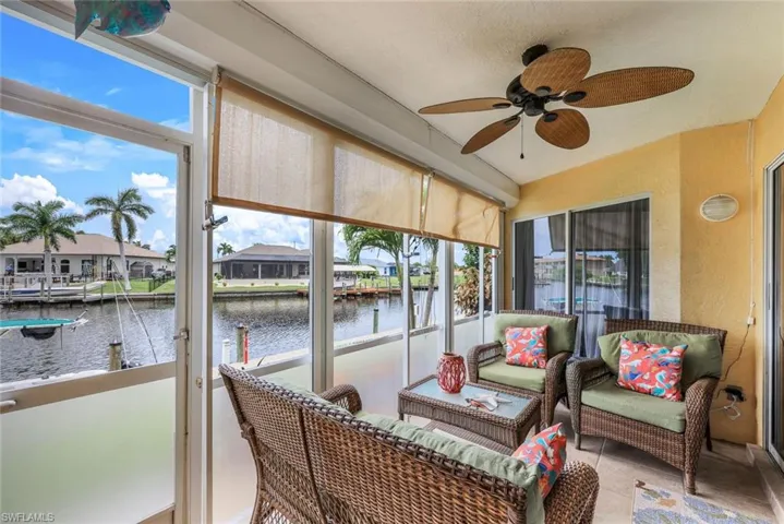 Sunroom featuring a healthy amount of sunlight, a water view, and ceiling fan