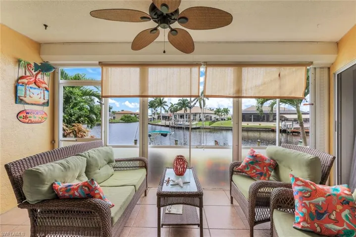Sunroom / solarium with ceiling fan and a water view