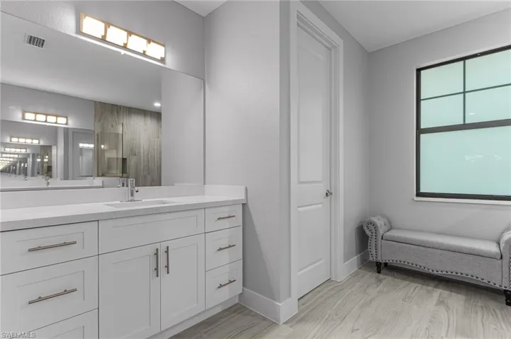 Full bath with vanity and light wood-type flooring