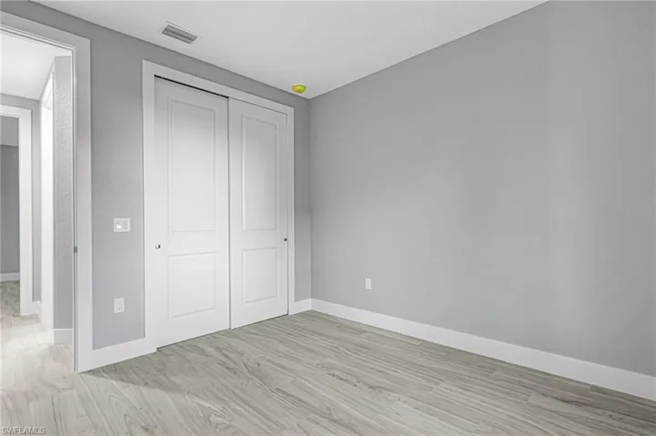 Unfurnished bedroom featuring light wood finished floors and a closet