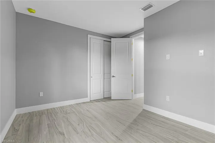 Unfurnished bedroom with light wood-style floors and a closet