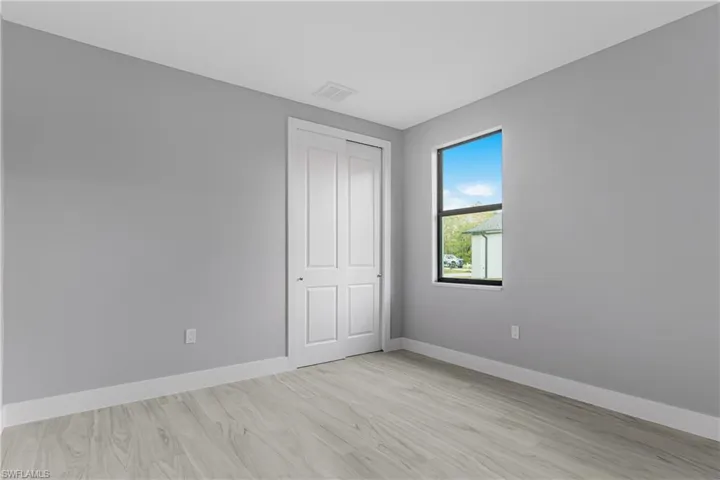 Unfurnished bedroom with light wood-style flooring and a closet