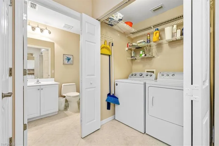 Laundry room featuring independent washer and dryer and light tile patterned floors
