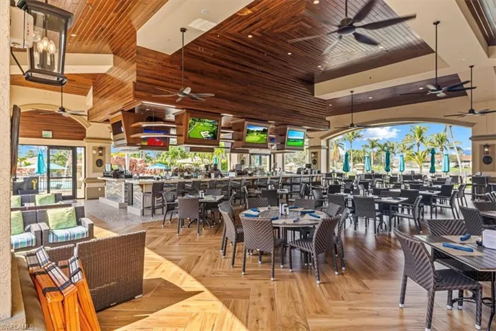 Dining room with ceiling fan, a towering ceiling, and wood ceiling