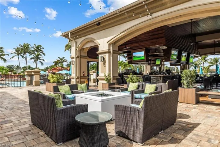 View of patio with a ceiling fan, an outdoor living space with a fire pit, and an outdoor pool
