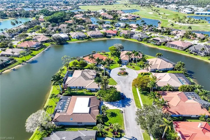Aerial view of property's location featuring nearby suburban area, a large body of water, and a local golf course