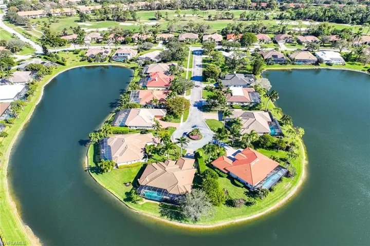 Aerial view of property and surrounding area featuring a large body of water and nearby suburban area