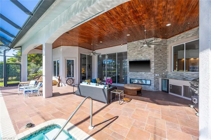 View of patio / terrace with a ceiling fan, a lanai, an outdoor living space, wine cooler, and grilling area