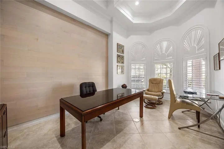 Home office with ornamental molding, a high ceiling, and light tile patterned floors