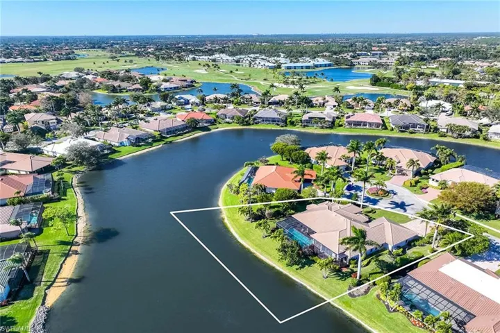 Aerial perspective of suburban area with a large body of water, a local golf course, and property boundaries highlighted