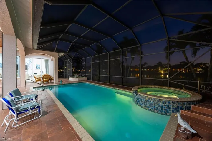 View of swimming pool featuring a sunroom, a pool with connected hot tub, a patio area, and a lanai