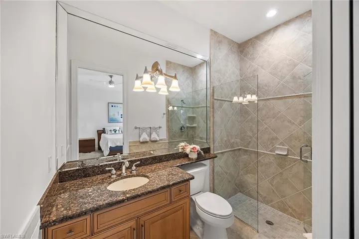 Ensuite bathroom with vanity, a stall shower, recessed lighting, and a ceiling fan