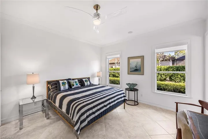 Bedroom with crown molding, ceiling fan, and tile patterned flooring