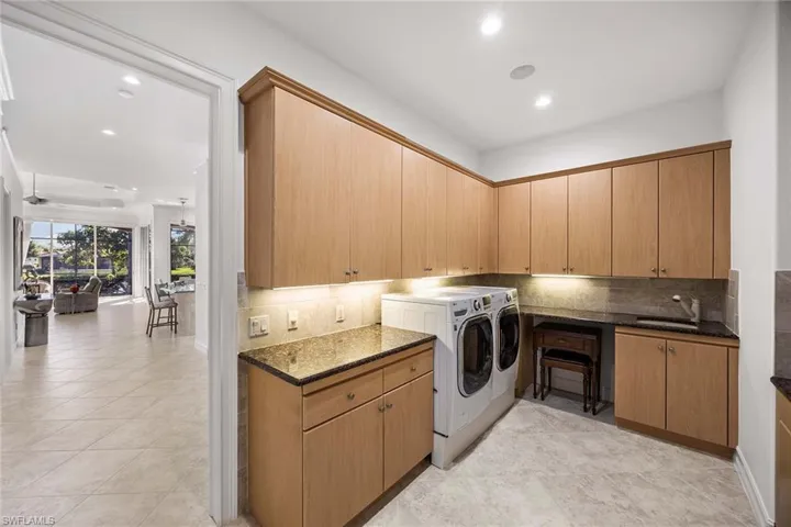 Washroom featuring cabinet space, recessed lighting, washer and clothes dryer, a ceiling fan, and light tile patterned floors