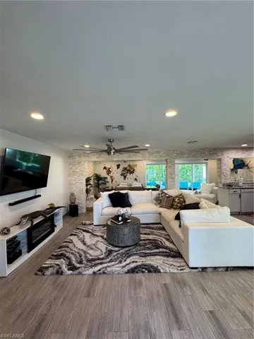 Living area featuring ceiling fan, wood finished floors, and recessed lighting