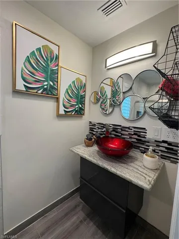 Bathroom with vanity, backsplash, and wood tiled floors