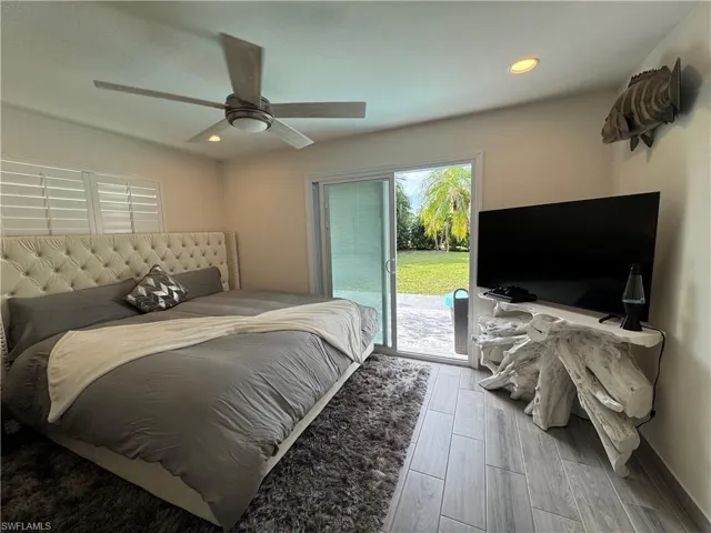 Bedroom featuring access to outside, wood finished floors, recessed lighting, and ceiling fan