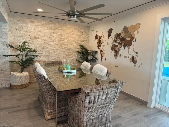 Dining room with crown molding, wood finished floors, and ceiling fan
