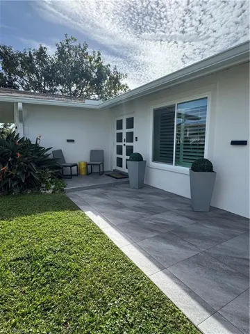 View of home's exterior with stucco siding, french doors, a patio, and a yard