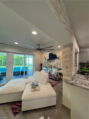 Living area featuring a ceiling fan, dark wood-type flooring, and recessed lighting