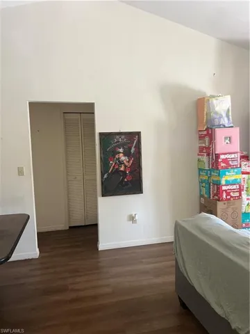 Bedroom with dark wood finished floors and a closet
