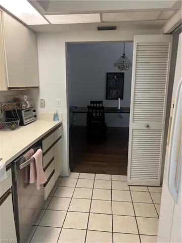 Kitchen with light countertops, light tile patterned flooring, dishwasher, and pendant lighting