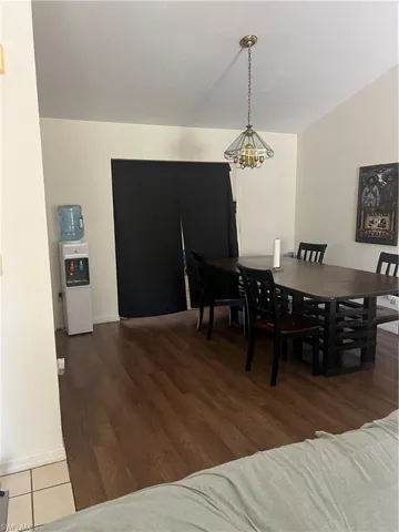Dining room with a chandelier and dark wood-style floors