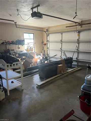 Garage with a textured wall and a garage door opener