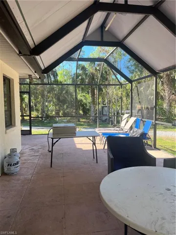 View of patio featuring glass enclosure and a sunroom