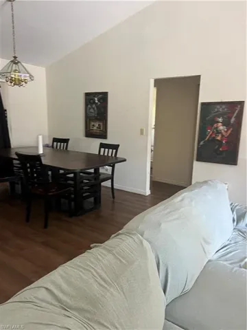 Living room with dark wood-type flooring and vaulted ceiling